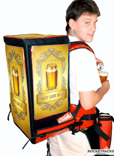 Promoter wearing a portable beer dispensing backpack with promotional advertising for mobile beverage service at events.